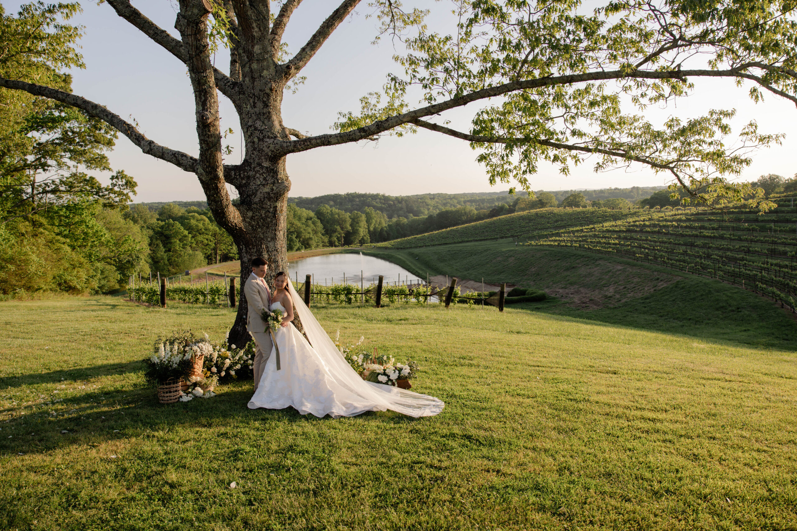 bride and groom pose with a tree and a pond during their Italian destination elopement