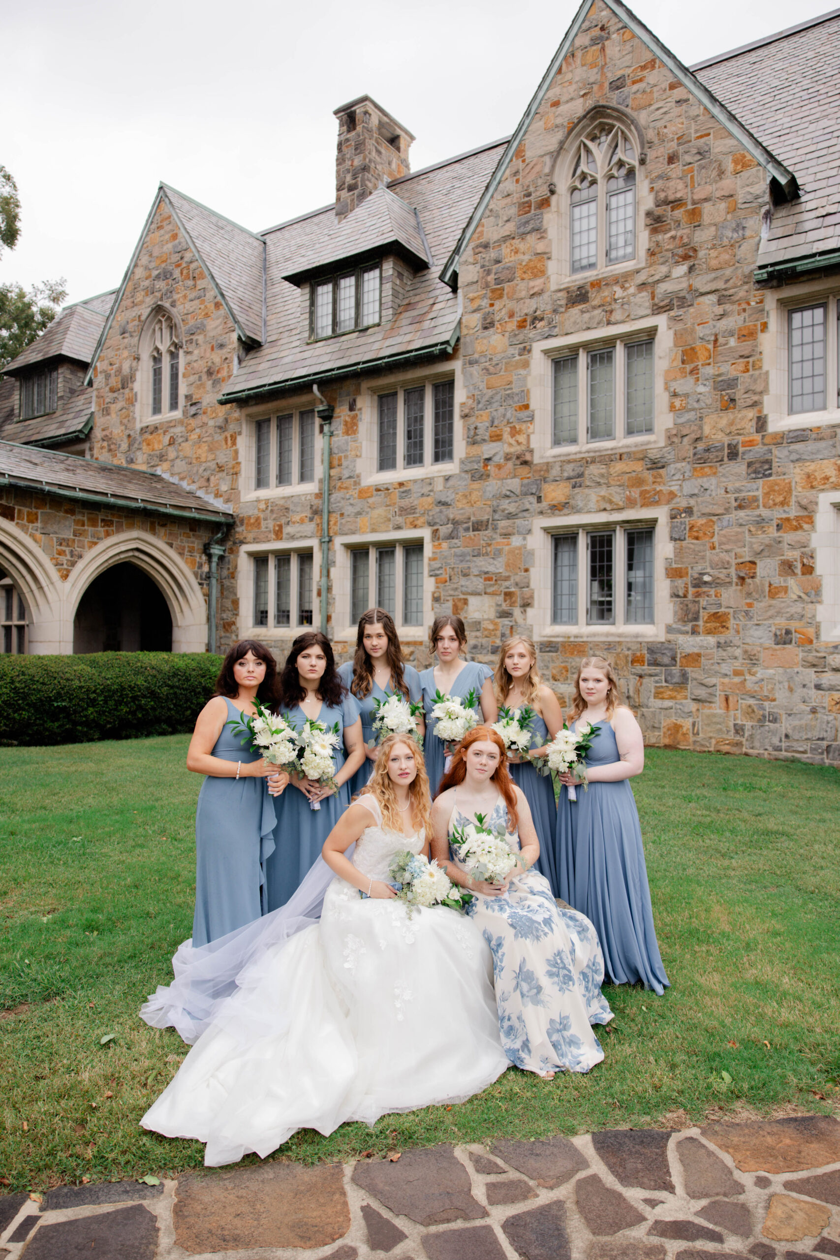 bride poses with her bridesmaids outside the stunning wedding venue