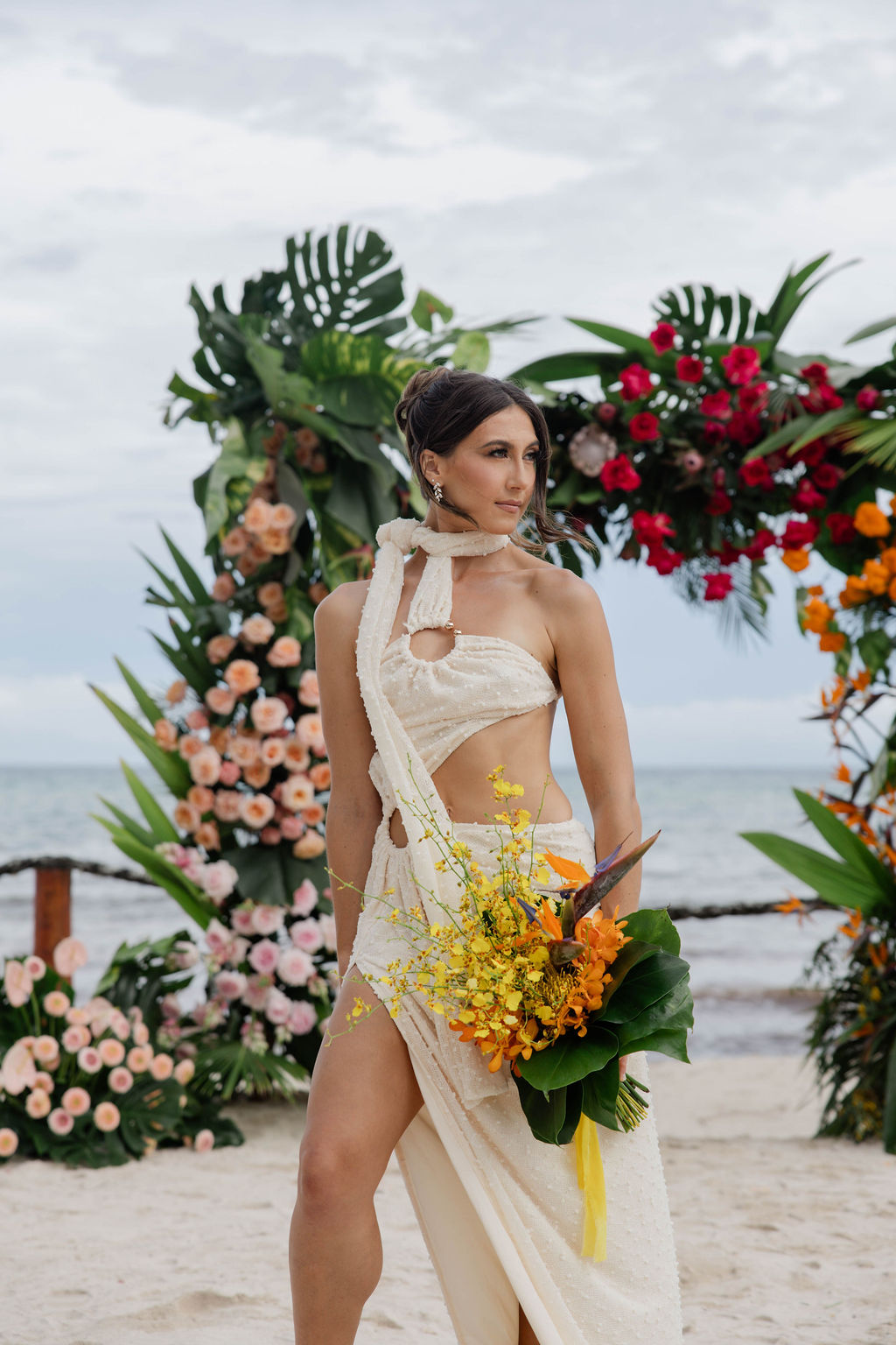 stunning bride poses for a photo with the wedding arch in the background
