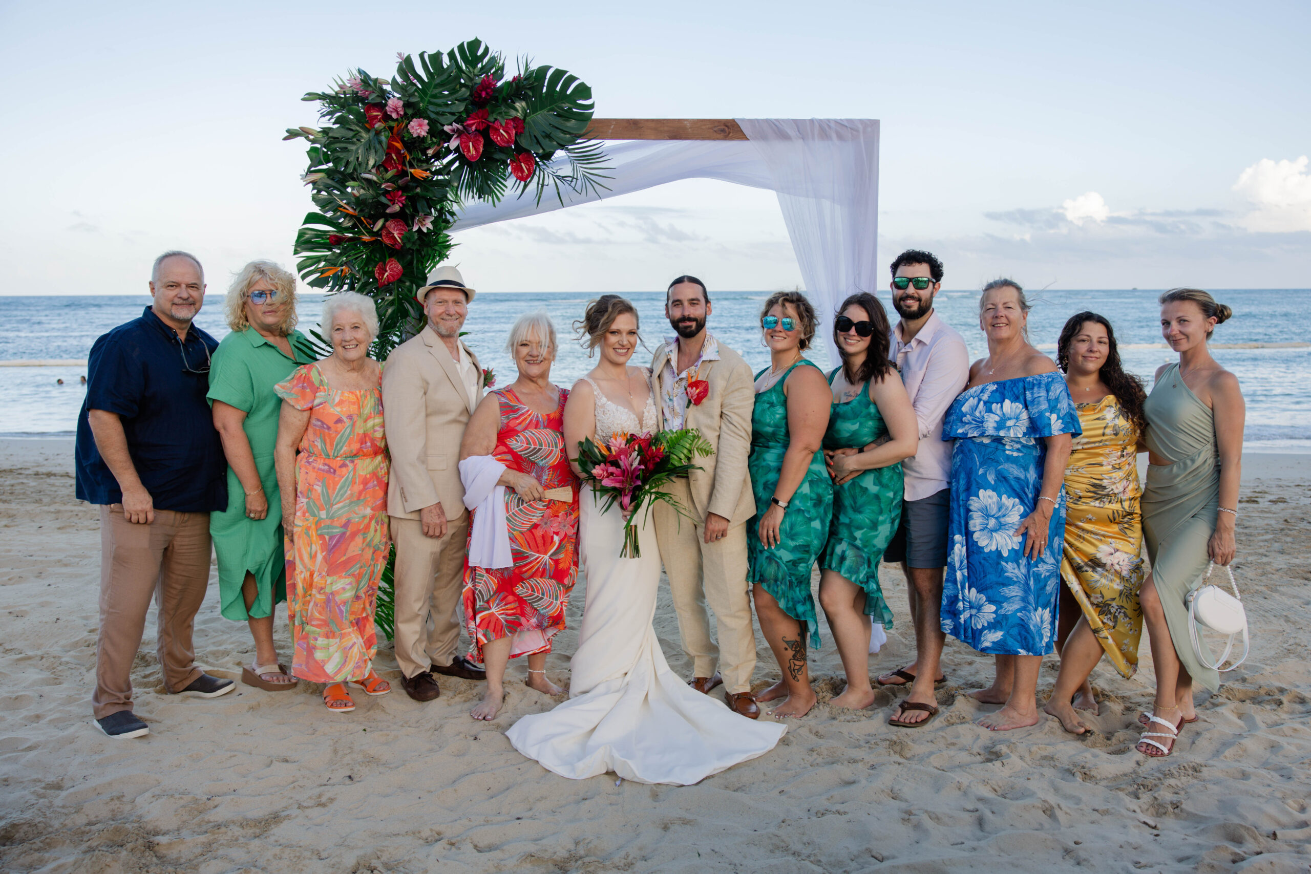wedding party poses for a photo at the beachfront ceremony site