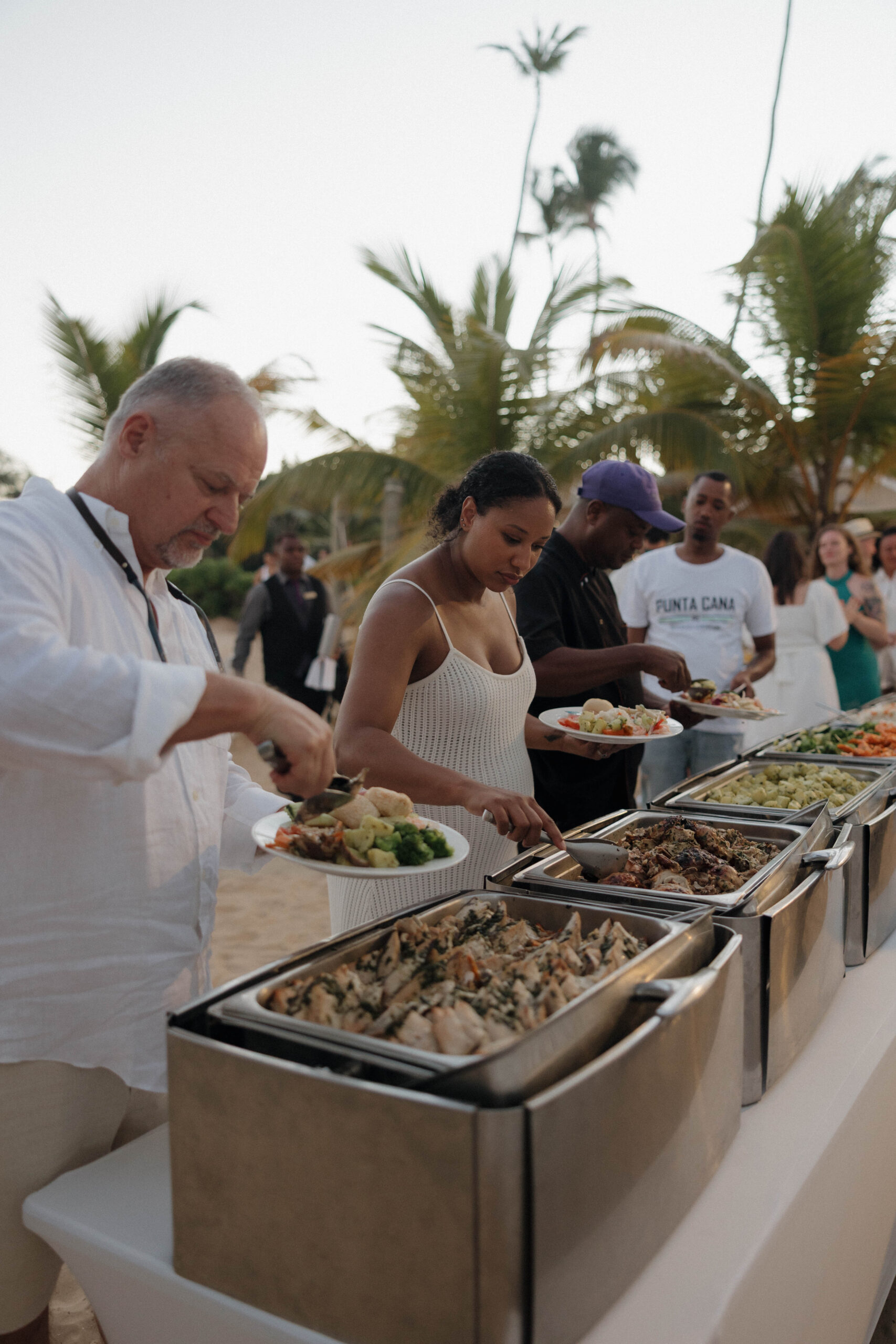 wedding guests get food from the line