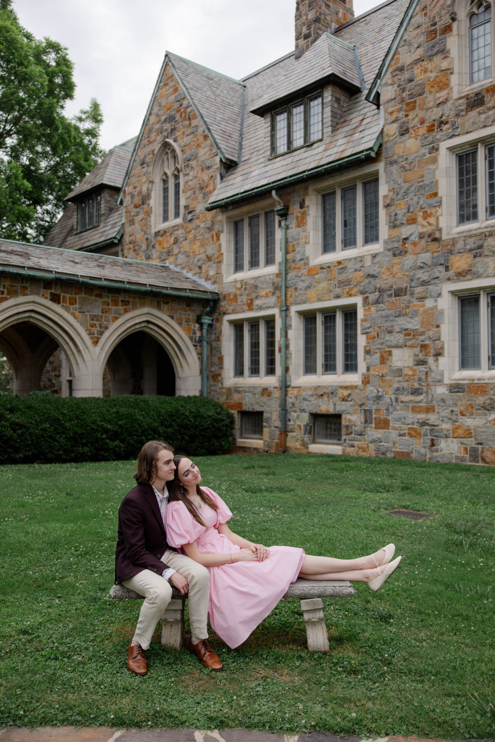 couple pose on a bench together 