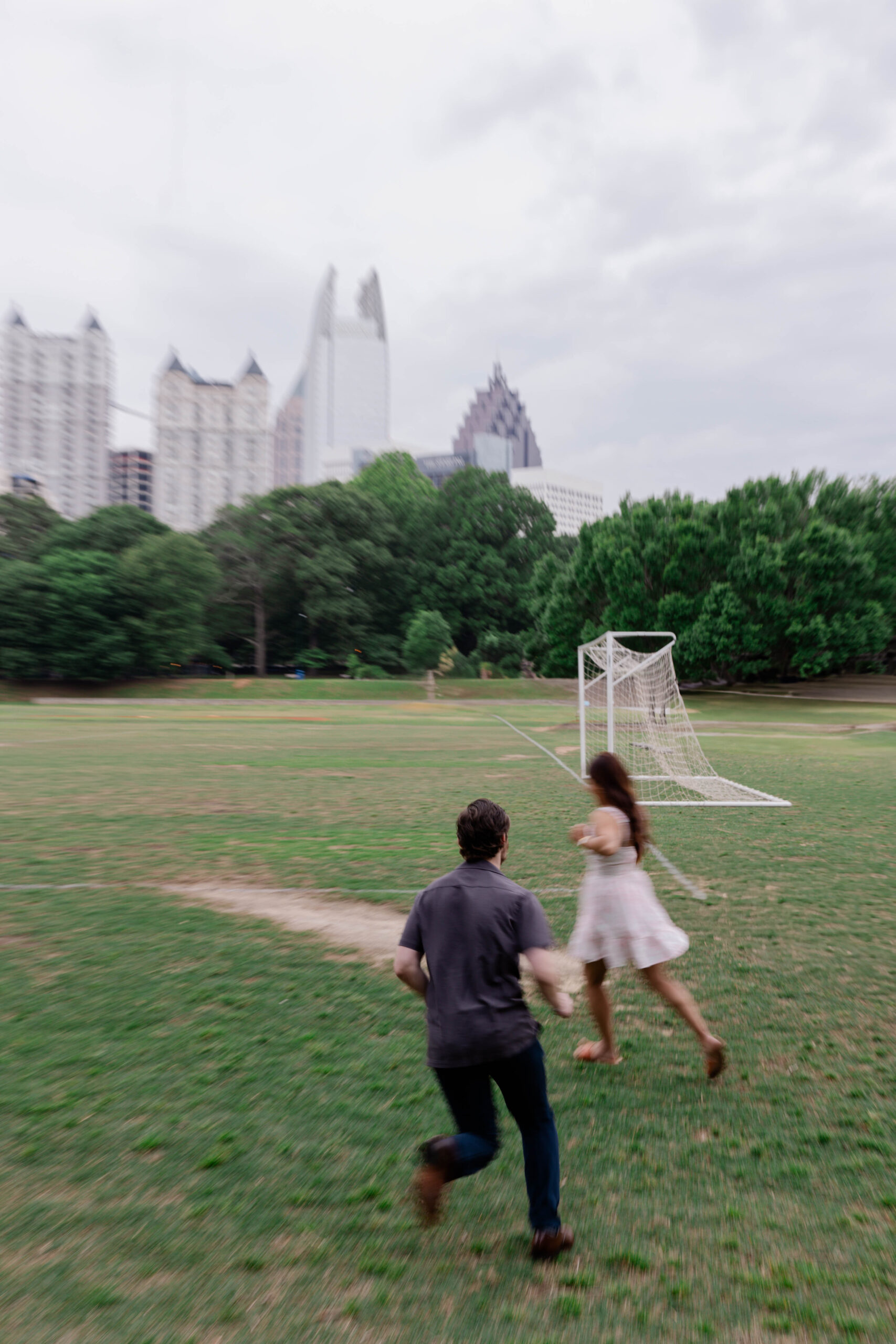 couple run and play during their spring engagement photoshoot in Atlanta