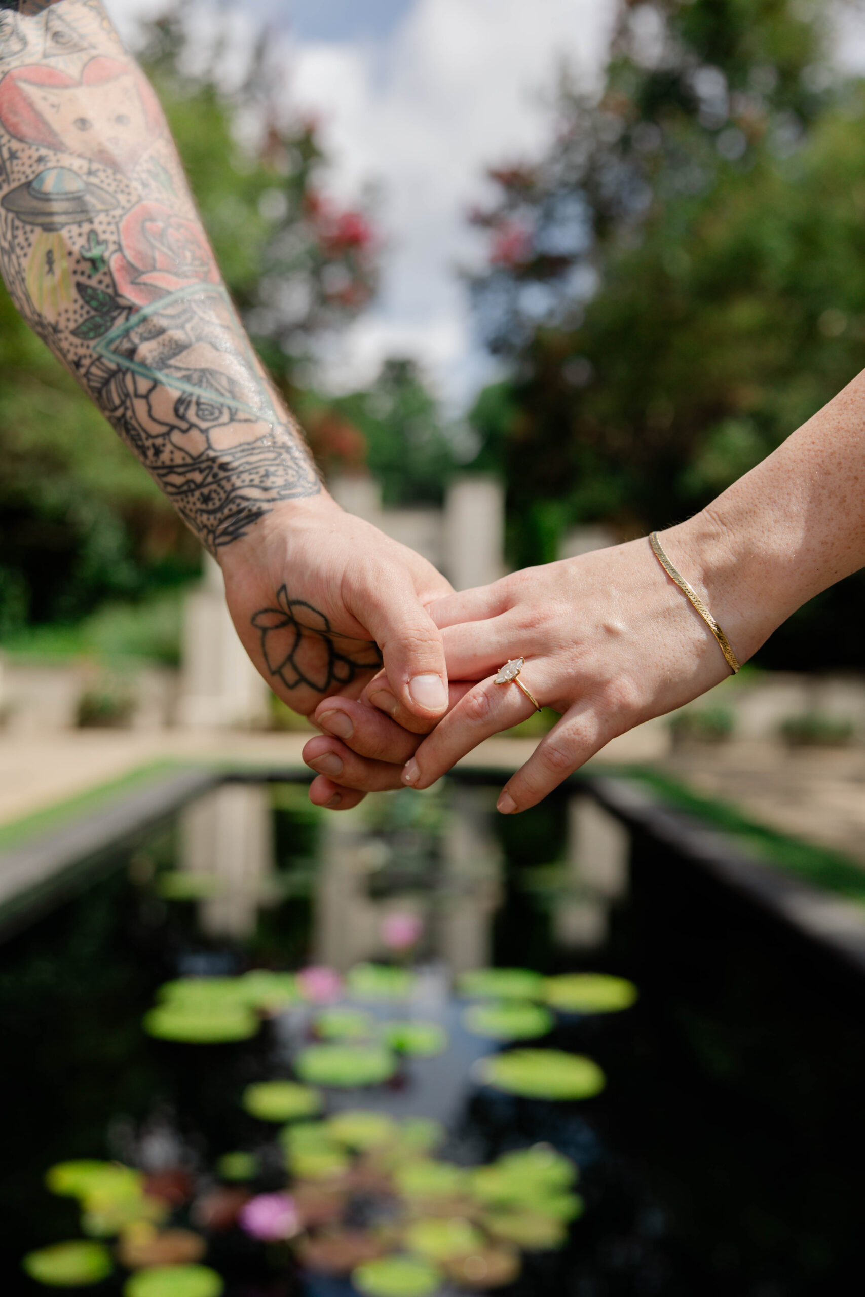 couple hold hands with the green Georgia spring in the background
