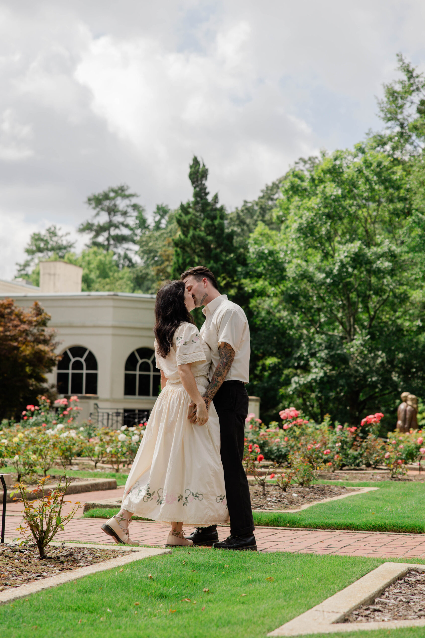 couple share a kiss in the botanical gardens, a kiss is always the a natural engagement photo pose!