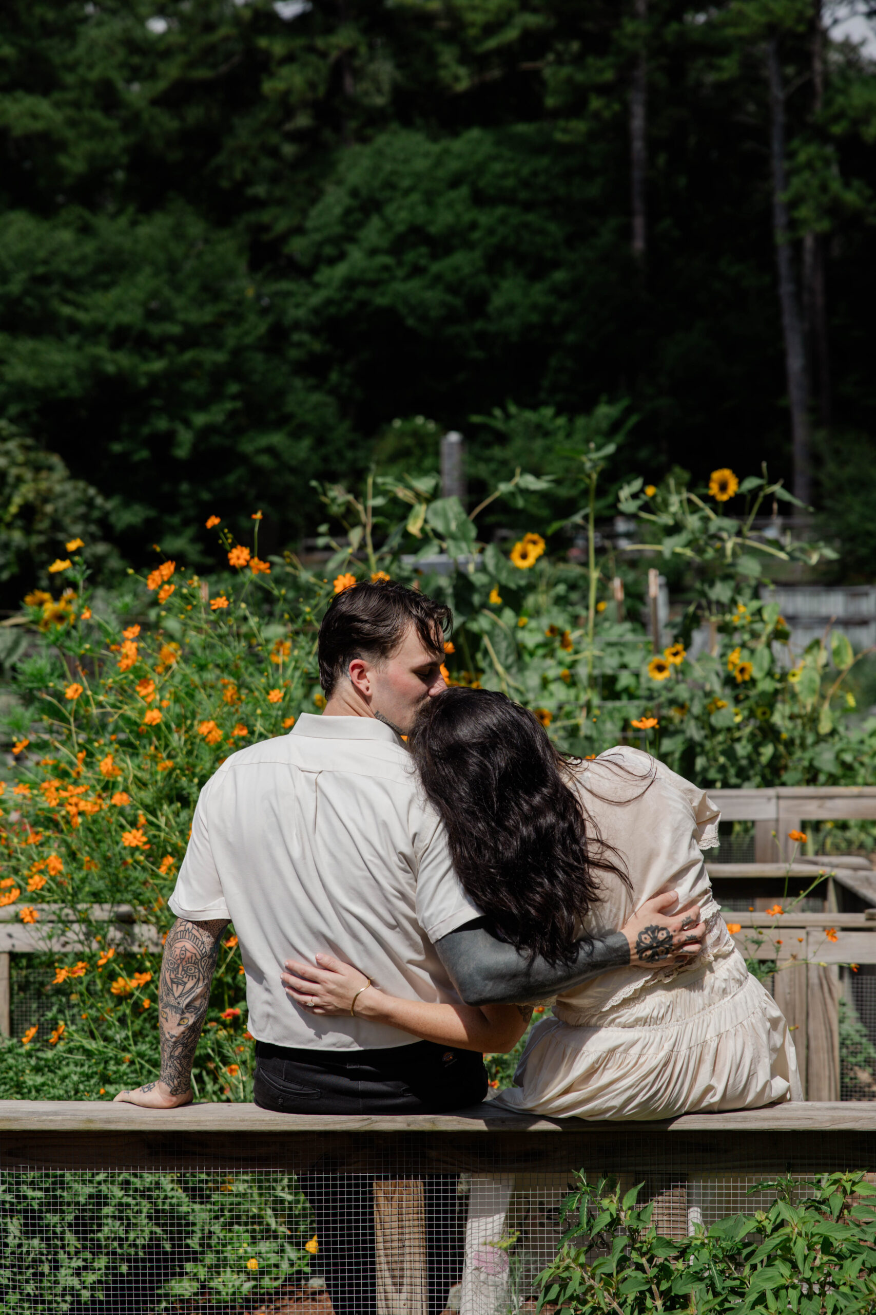 couple share a kiss in the botanical gardens, a kiss is always the a natural engagement photo pose!