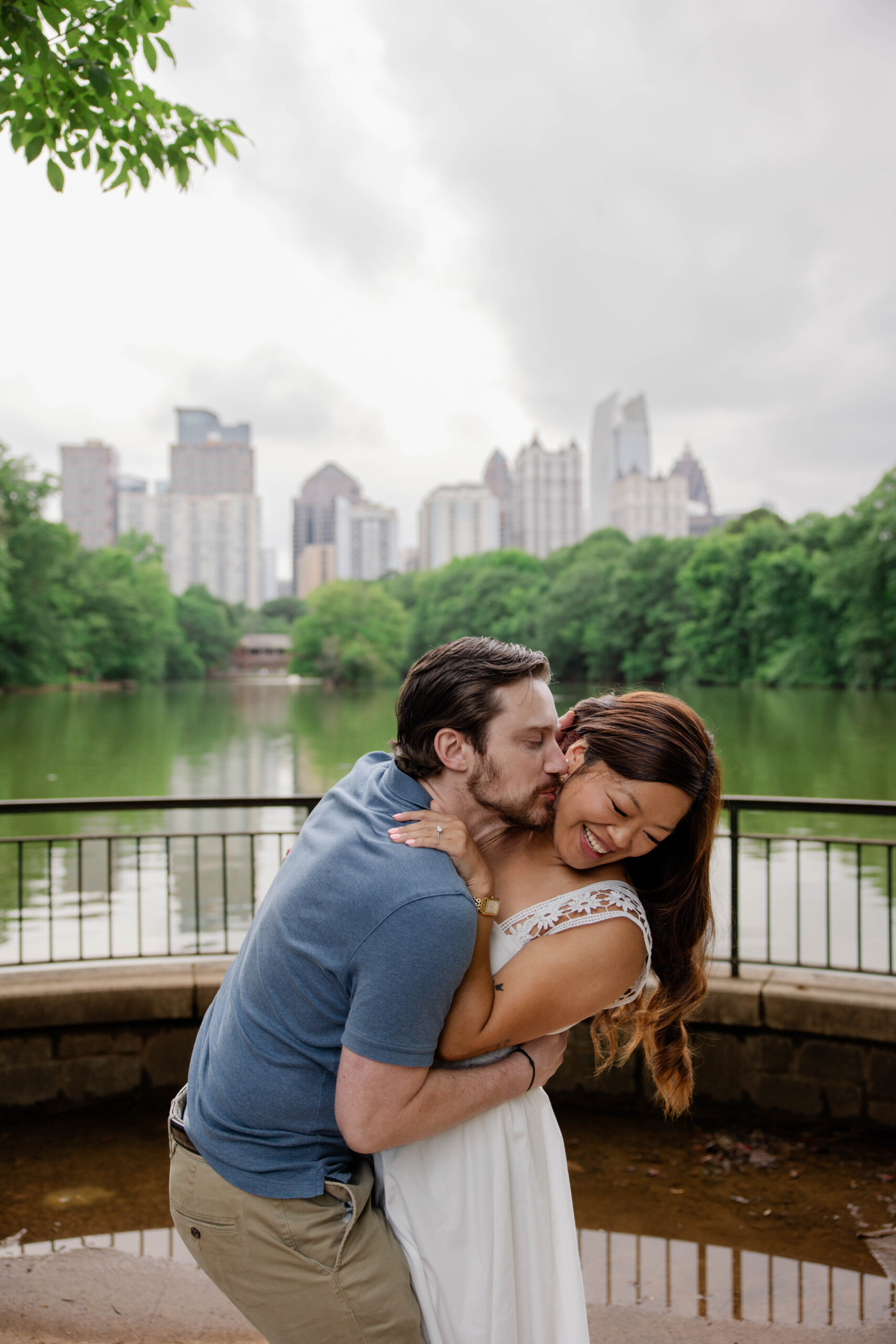 couple share a kiss with Atlanta standing in the background