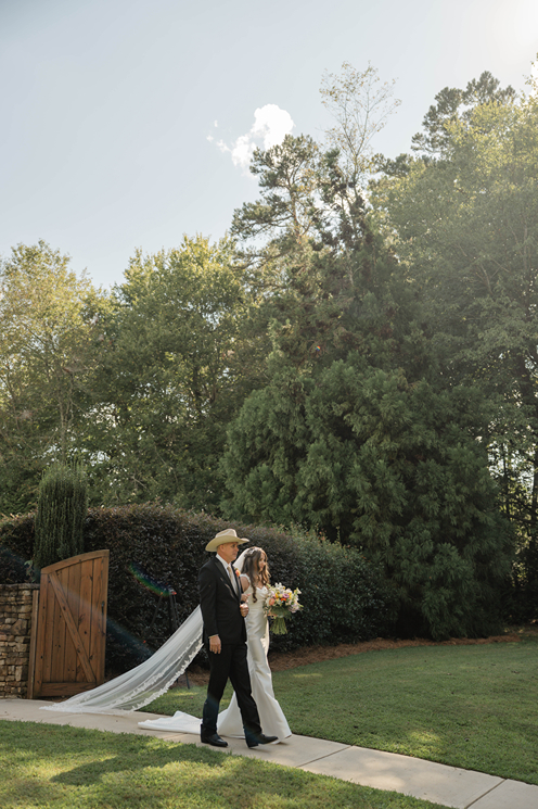 bride enters with her dad as the Georgia wedding ceremony takes place