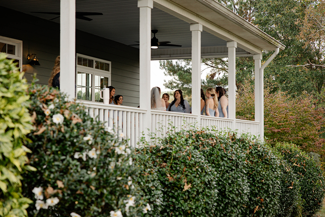 bridal party hangs out on the classic southern wrap around porch before the beautiful Georgia wedding day