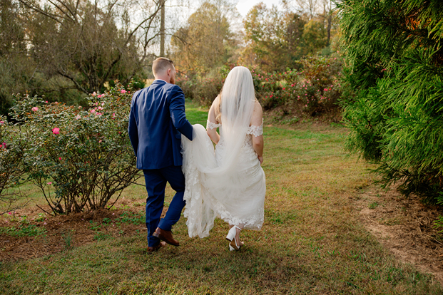 bride and groom walk through the garden during their Georgia wedding day at one of the top wedding locations in north georgia!