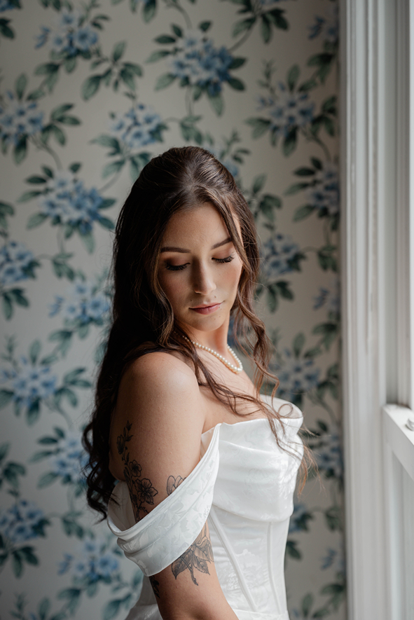 bride poses for a photo with the floral wallpaper in the background