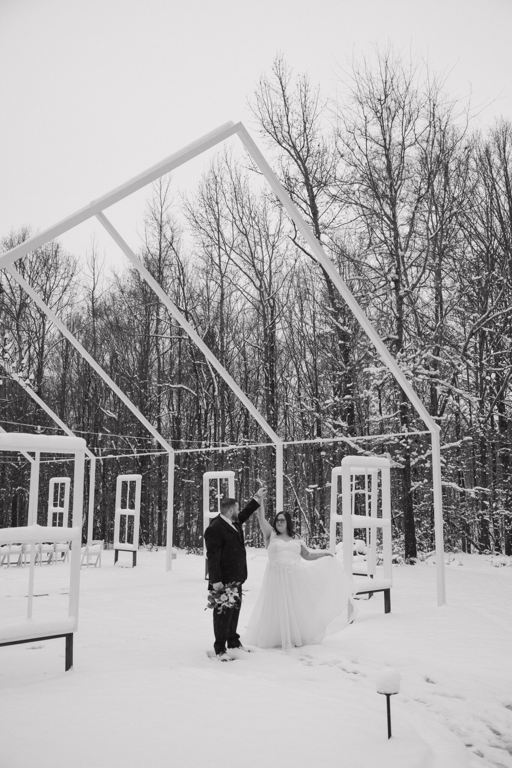 bride and groom dance in the snow during their winter wedding at a top wedding locations in north georgia