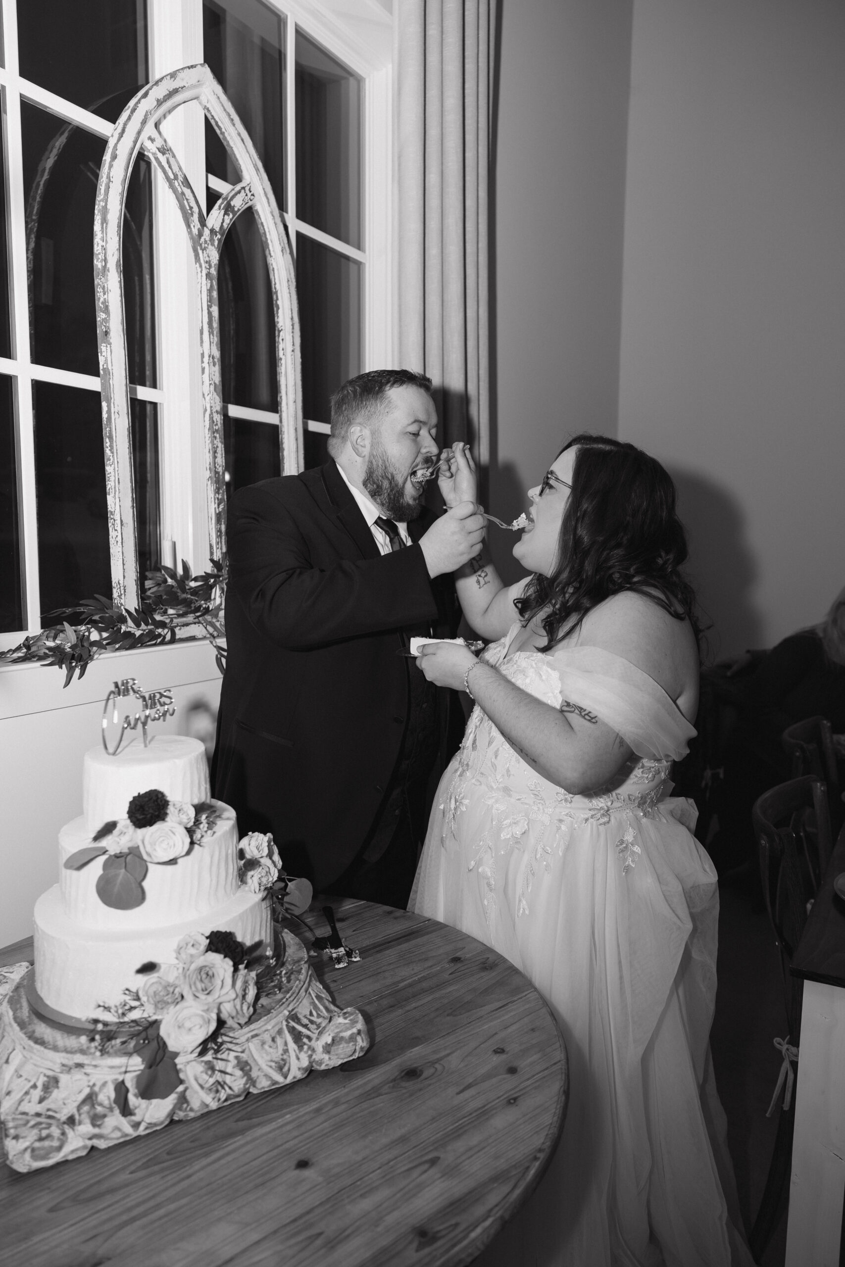 bride and groom feed each other cake during their emotional wedding reception
