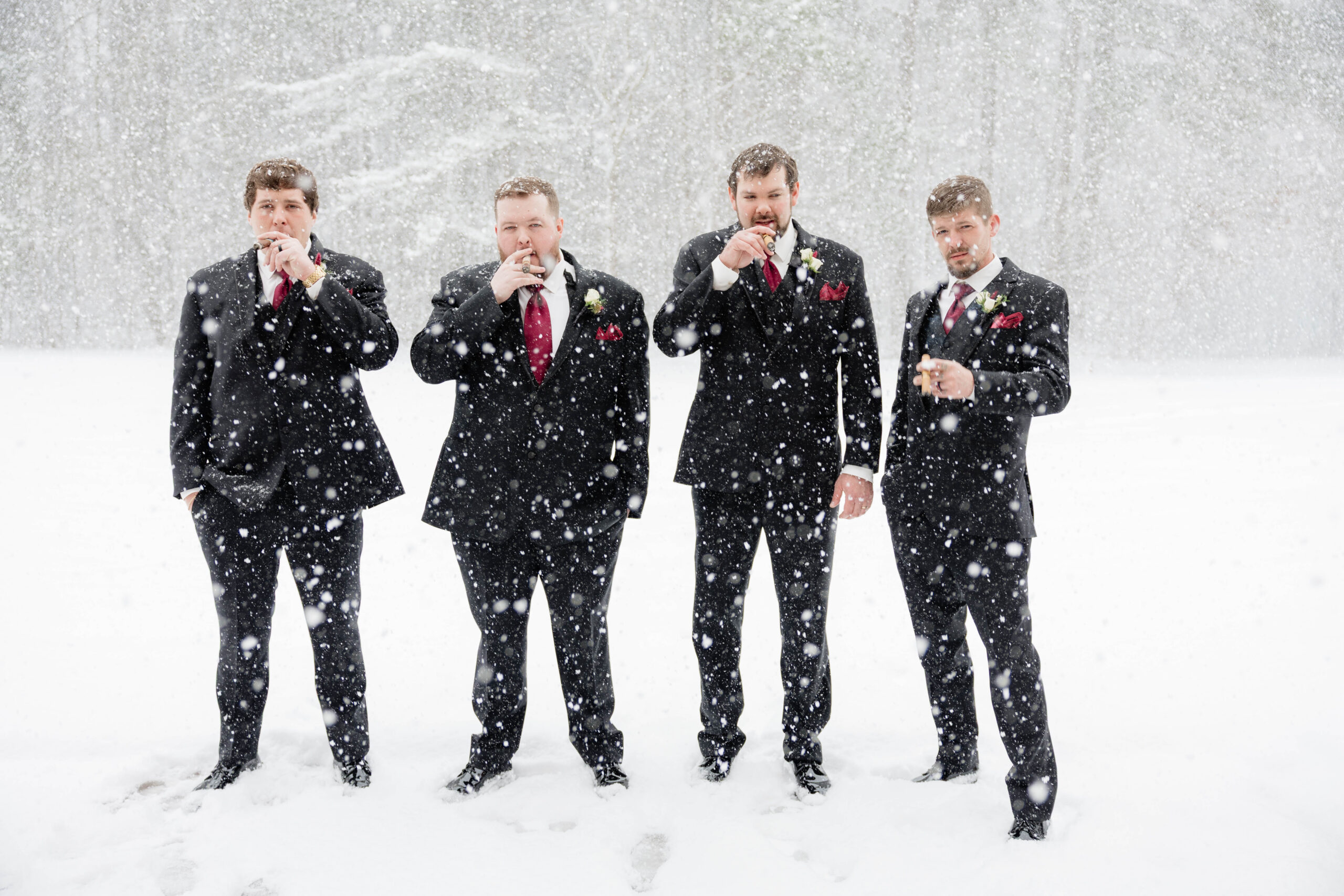 groomsmen celebrate with the groom in the pouring snow