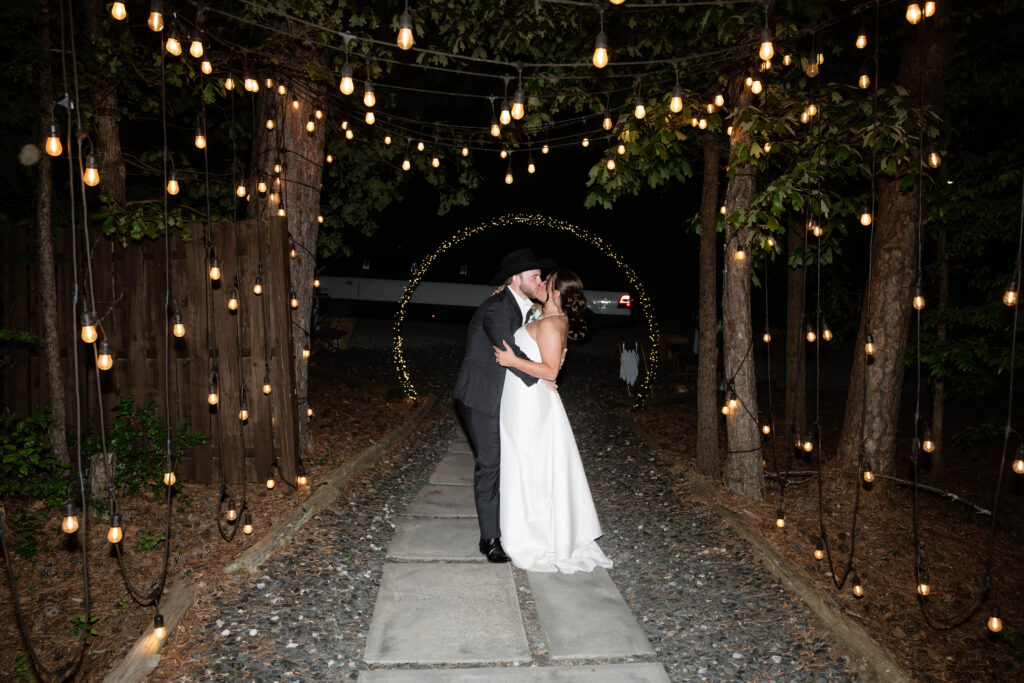 bride and groom share a kiss as they exit their wedding day