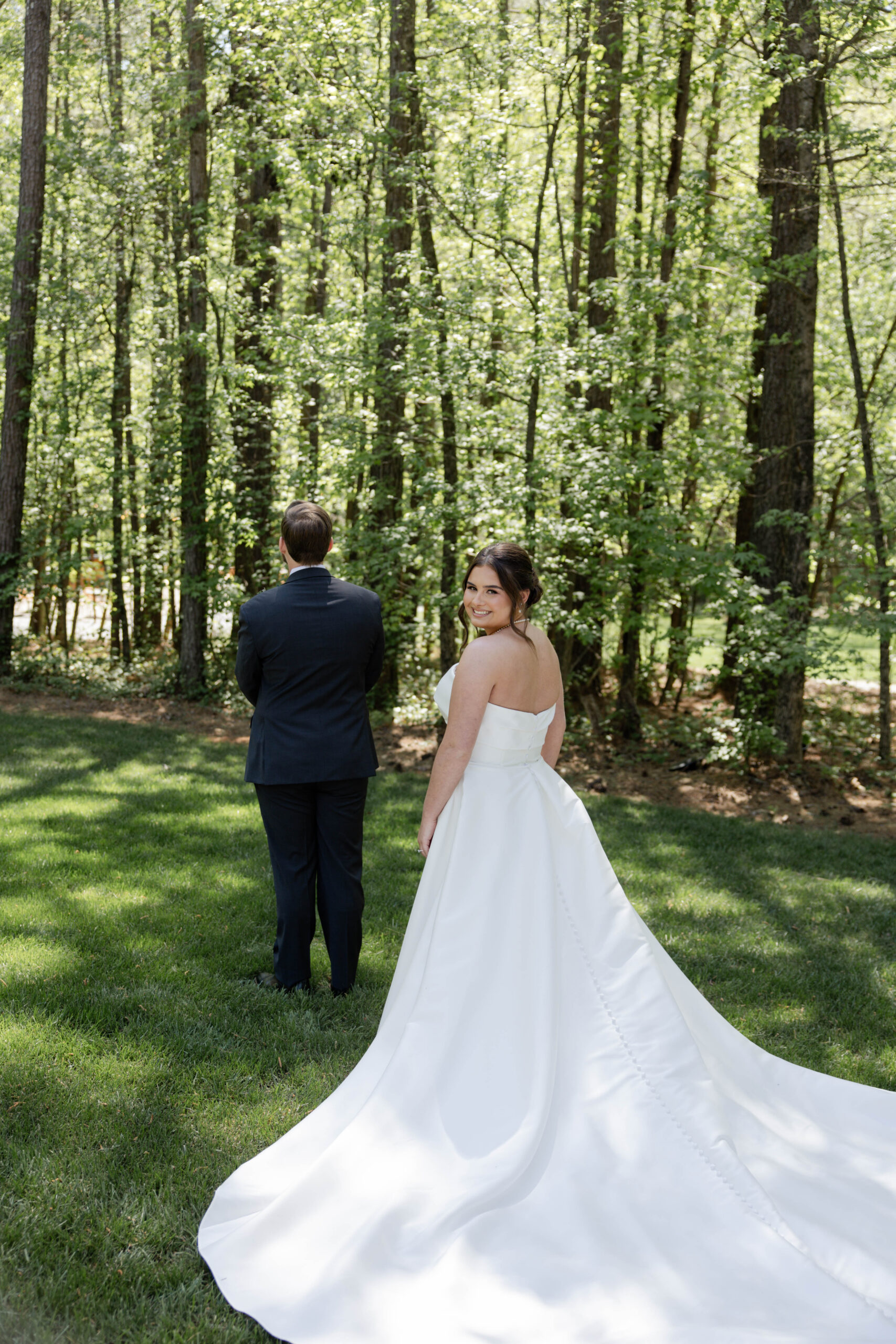 beautiful emotional first look under the trees during a stunning wedding day at the stunning