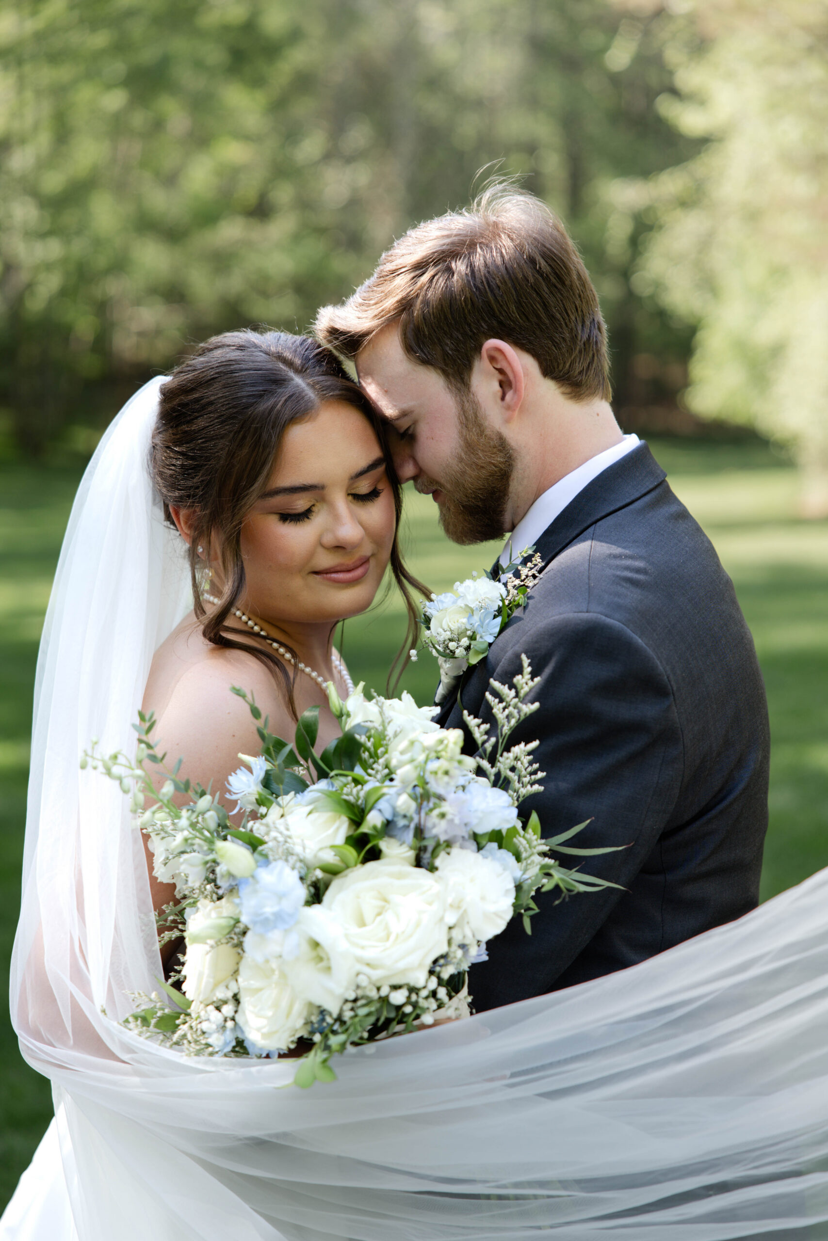 bride and groom share a moment wrapped in her veil