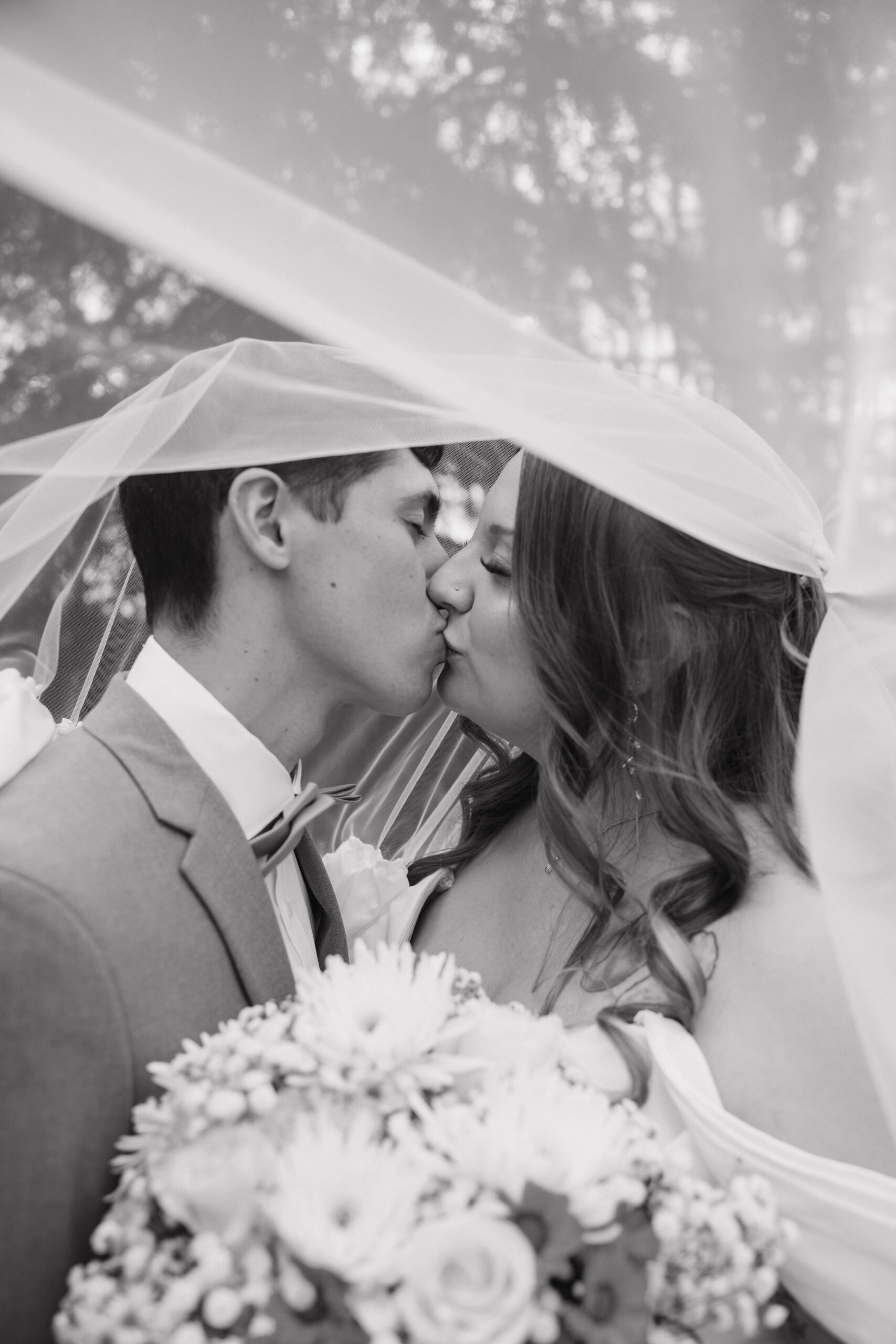 bride and groom share a kiss under the veil during their beautiful Juliet Chapel wedding day