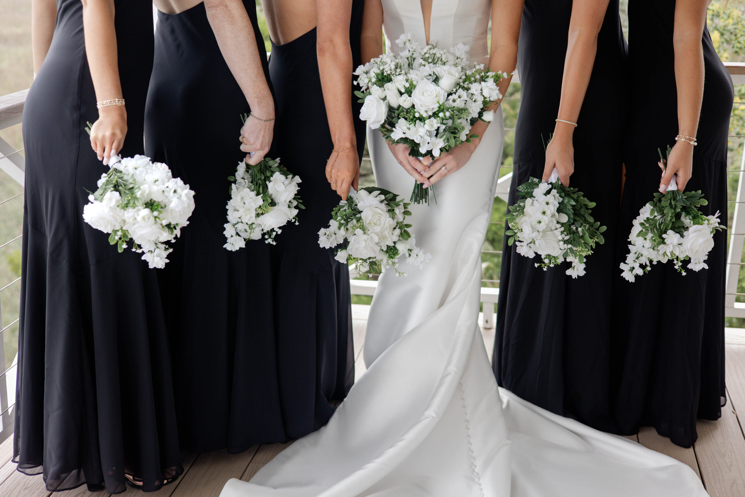 bridal party poses for a photo together with their bouquets