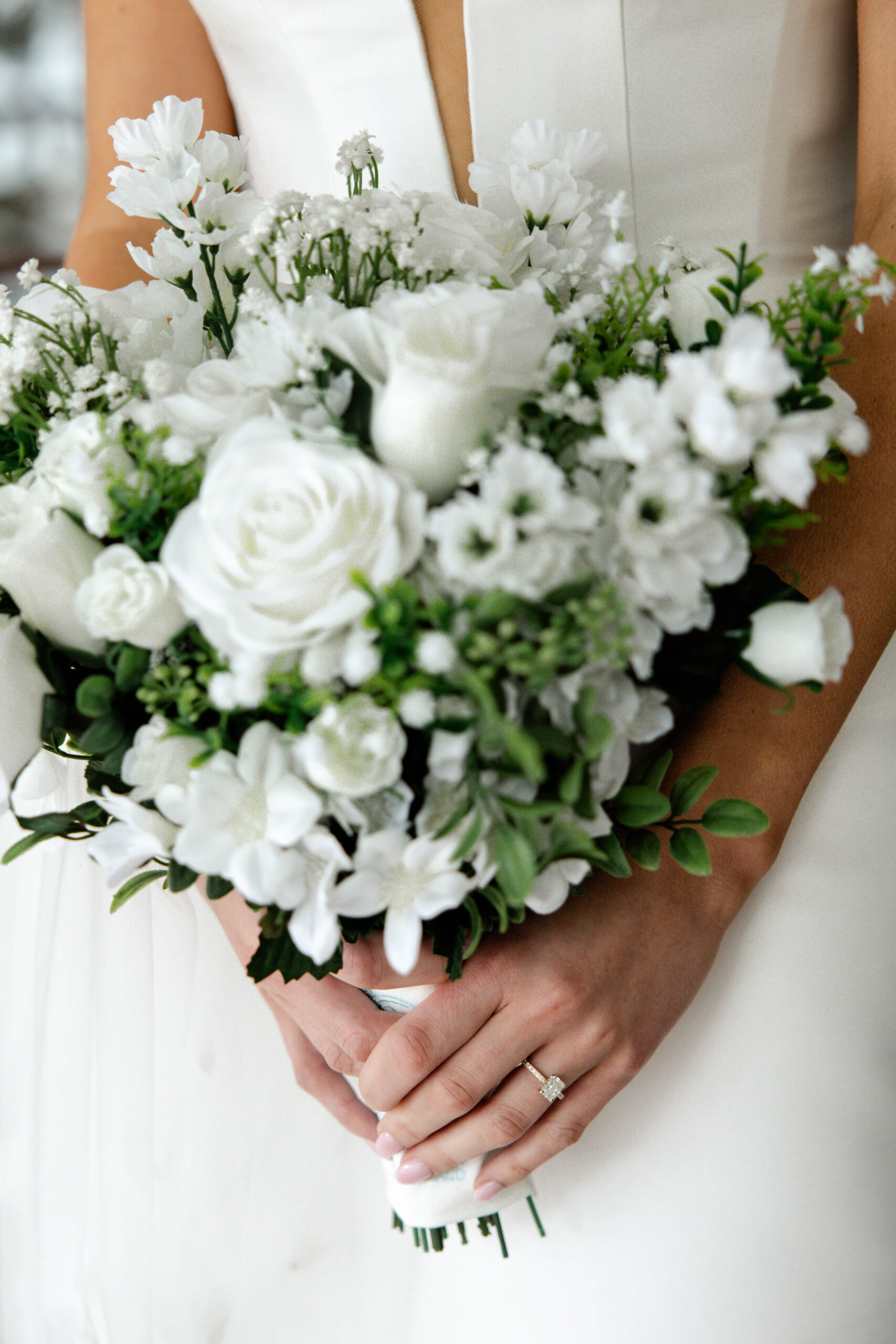 bride poses with her bouquet on the marshy walking path