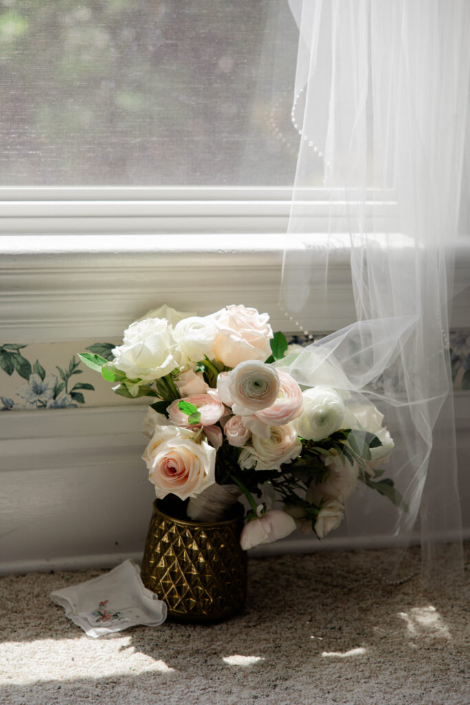 bridal bouquet sits in front of the window 